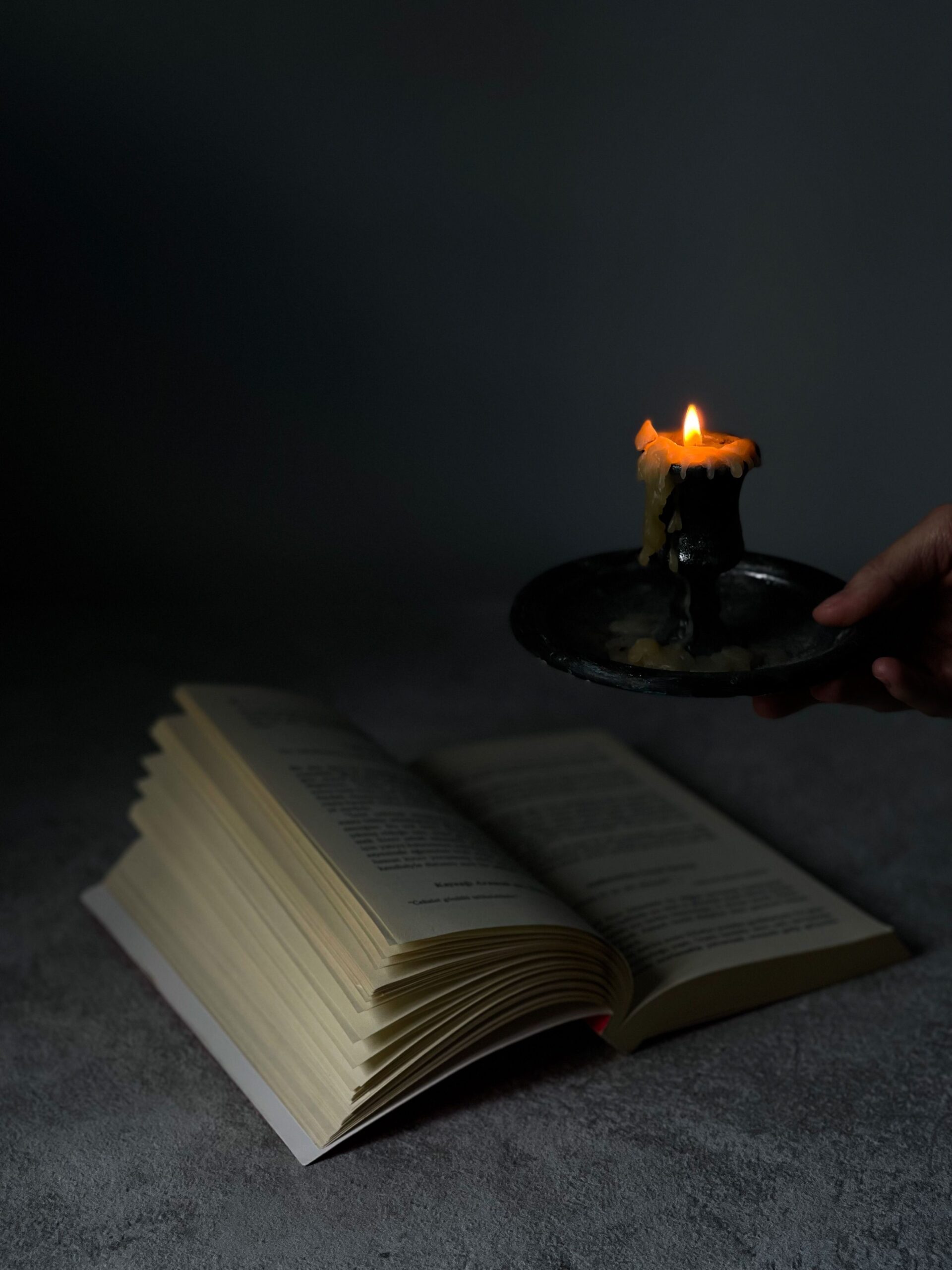 Livre ouvert éclairé par une bougie, évocation de la bibliomancie